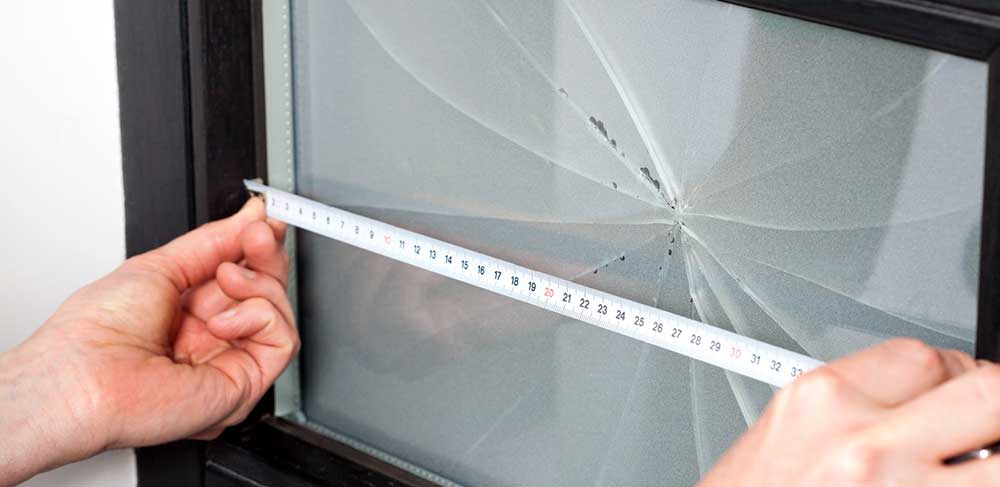 Prise des mesures pour remplacer une vitre de fenêtre brisée
